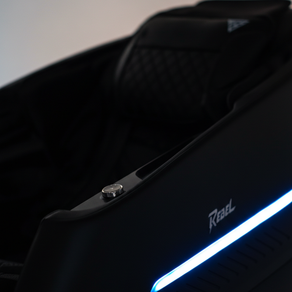 Close-up of the Rebel 4D black massage chair with blue LED lighting in a cinematic studio