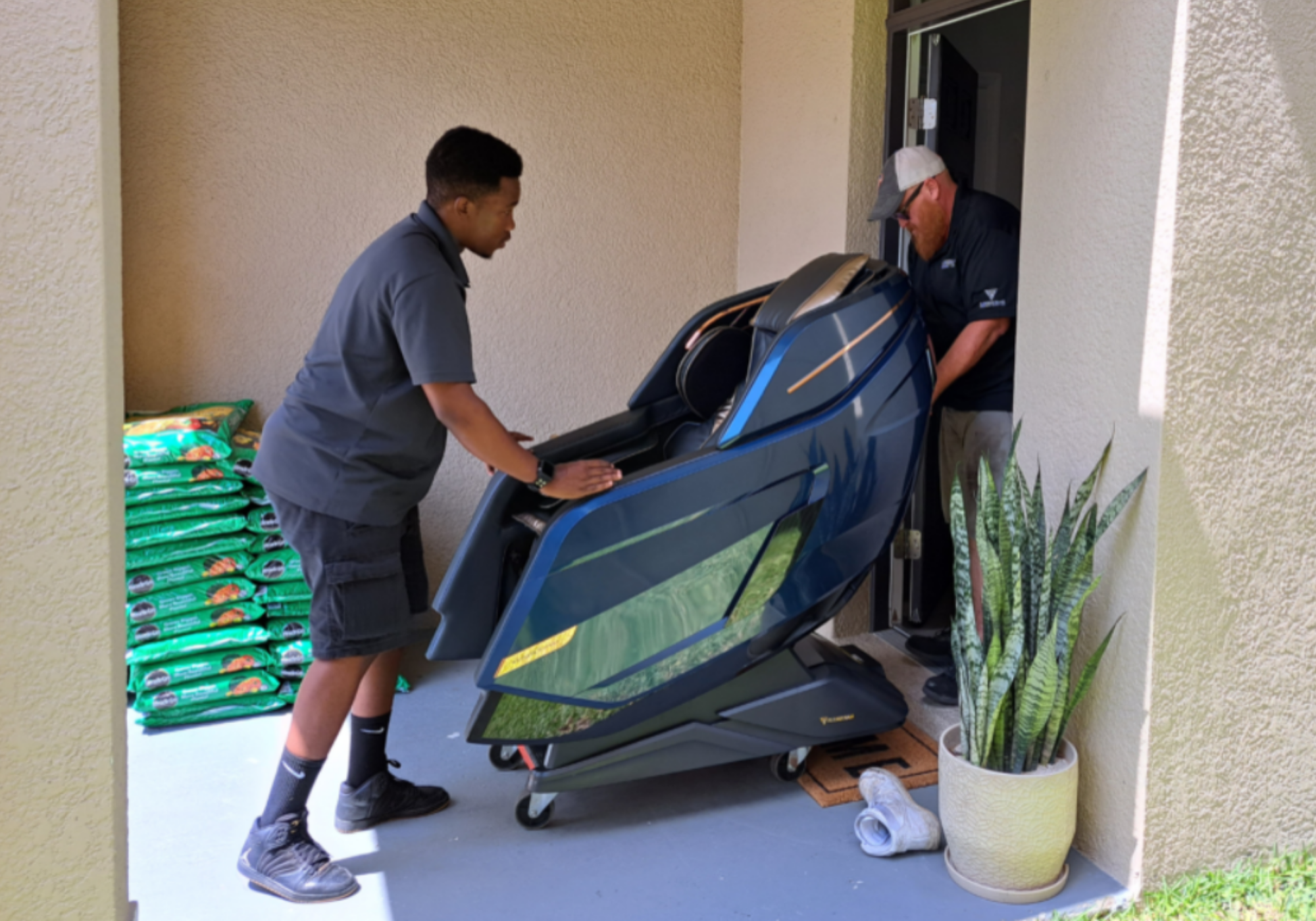 Two men moving a large piece of exercise equipment outside a building.