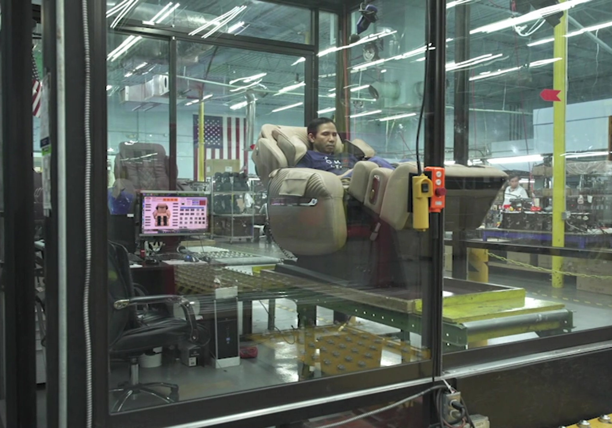 Technician testing a massage chair in a quality control facility, running diagnostics to ensure performance and reliability.