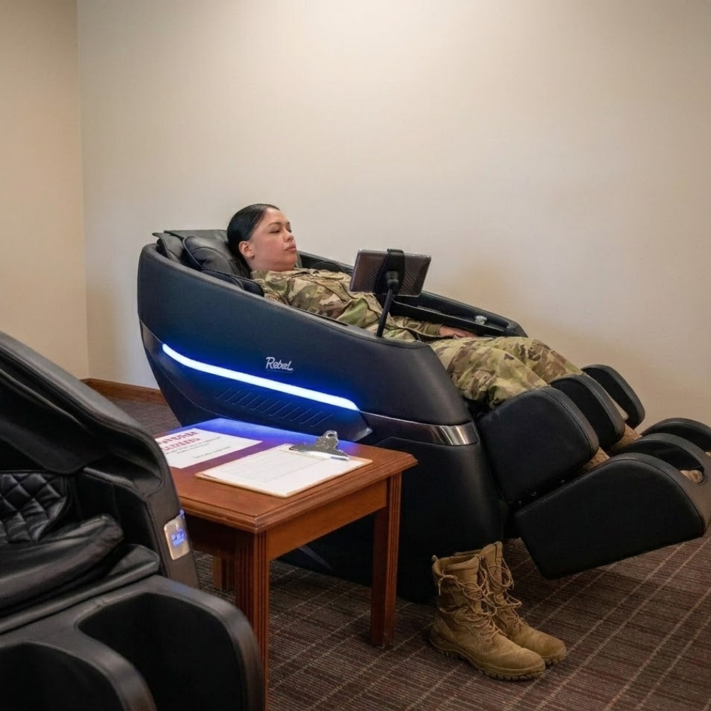 US Space Force service member relaxing in a black Floridian Brand Rebel 4D massage chair during a military recovery and mental wellness initiative.